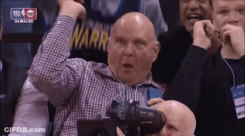 A Bald Man In A Plaid Shirt Holds His Fist In The Air While Watching A Basketball Game Sponsored By Tnt GIF