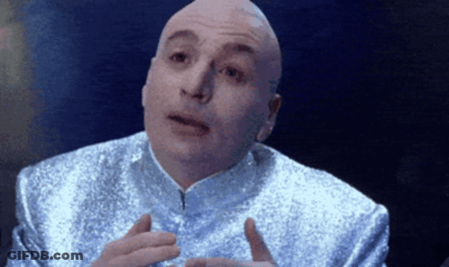 A Bald Man In A Silver Suit Is Talking GIF