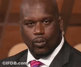 A Bald Man In A Suit And Tie Is Blowing A Kiss . GIF