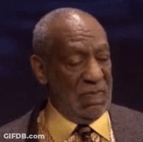 A Bald Man In A Suit And Tie Is Making A Face . GIF