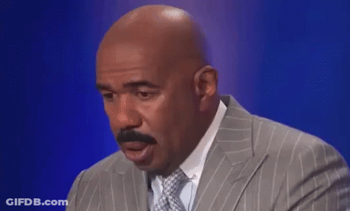 A Bald Man In A Suit And Tie Is Making A Funny Face . GIF