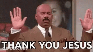 A Bald Man In A Suit And Tie Is Raising His Hands In The Air And Saying `` Thank You Jesus '' . GIF