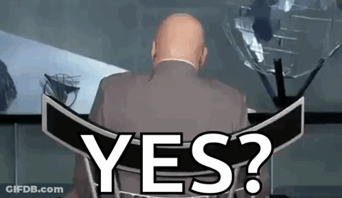 A Bald Man In A Suit Is Sitting In Front Of A Sign That Says Yes ? GIF