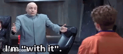 A Bald Man In A Suit Is Standing In Front Of A Man In An Orange Jacket . GIF
