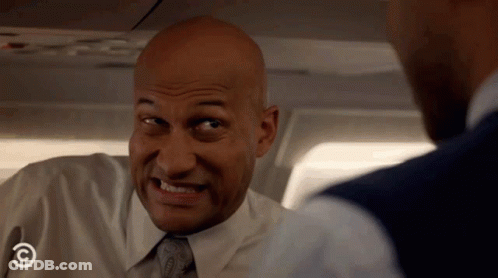 A Bald Man In A White Shirt And Tie With A Comedy Central Logo On His Chest GIF