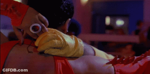 A Bald Man In A Yellow Shirt Is Being Hugged By A Woman GIF