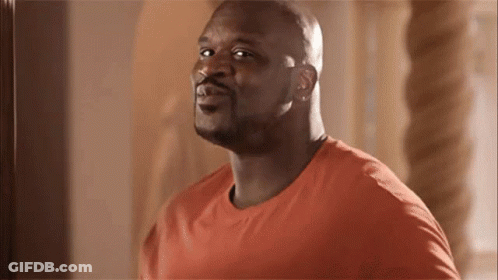 A Bald Man In An Orange Shirt Is Looking At The Camera And Smiling . GIF