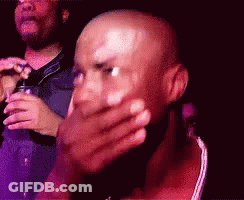 A Bald Man Is Covering His Face With His Hand GIF