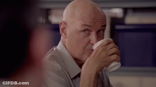 A Bald Man Is Drinking A Cup Of Coffee From A Plastic Cup . GIF