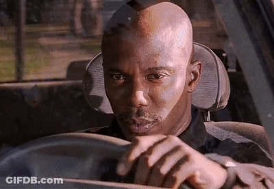 A Bald Man Is Driving A Car And Looking At Something GIF