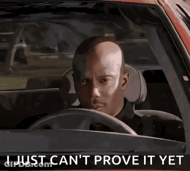 A Bald Man Is Driving A Car With The Words `` I Just Can 'T Prove It Yet '' Written On The Steering Wheel . GIF