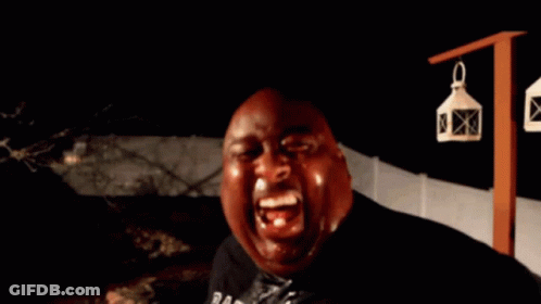 A Bald Man Is Holding A Bottle In His Hand And Looking At The Camera GIF