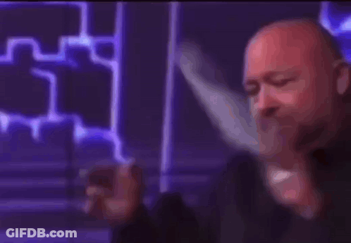 A Bald Man Is Holding A Cell Phone In His Hand And Says Liberal . GIF