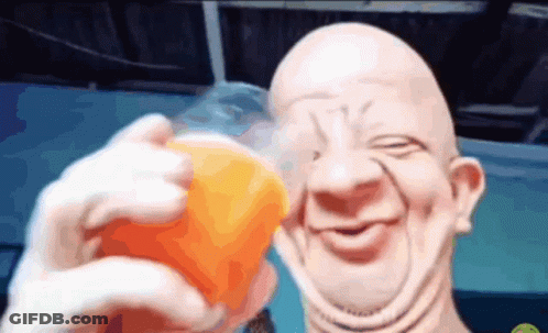 A Bald Man Is Holding A Cup Of Orange Juice And Smiling GIF