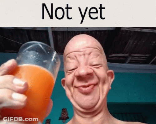 A Bald Man Is Holding A Glass Of Orange Juice And Smiling GIF