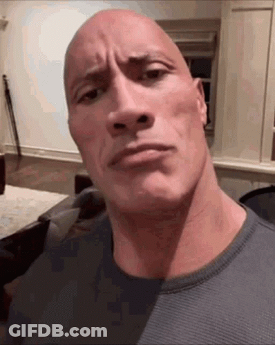 A Bald Man Is Making A Funny Face While Wearing A Grey Sweater . GIF