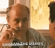 A Bald Man Is Sitting At A Table Drinking A Glass Of Wine . GIF