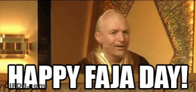 A Bald Man Is Sitting At A Table With The Words `` Happy Faja Day '' Written On The Screen . GIF