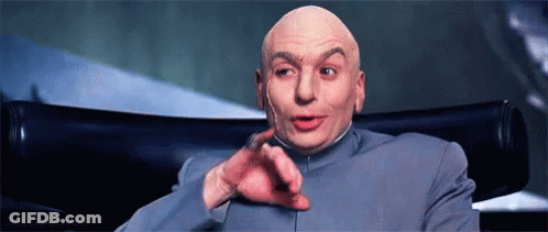 A Bald Man Is Sitting In A Chair And Pointing At The Camera GIF