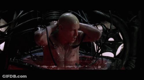 A Bald Man Is Sitting In A Red Liquid GIF