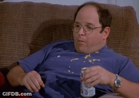 A Bald Man Is Sitting On A Couch Eating Chips And Drinking Bud Light GIF