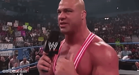 A Bald Man Is Standing In A Boxing Ring With His Arms Outstretched . GIF