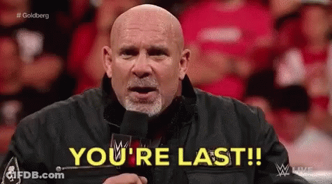 A Bald Man Is Standing In Front Of A Microphone And Says You 'Re Last . GIF