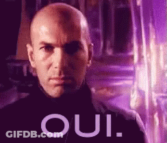 A Bald Man Is Standing In Front Of A Purple Background With The Word Oui Written On It . GIF