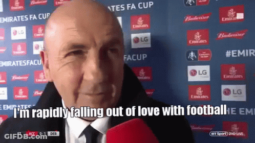 A Bald Man Is Talking Into A Microphone With The Words " I 'M Rapidly Falling Out Of Love With Football " Behind Him GIF
