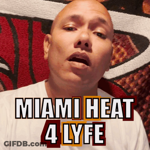 A Bald Man Is Wearing A White Shirt With The Words Miami Heat 4 Lyfe On It GIF
