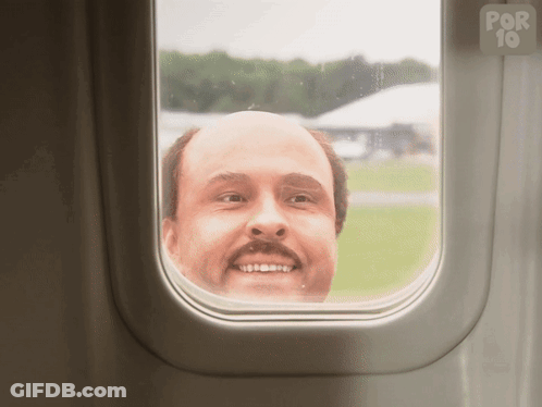A Bald Man Looks Out Of An Airplane Window With A Por 10 Logo In The Background GIF