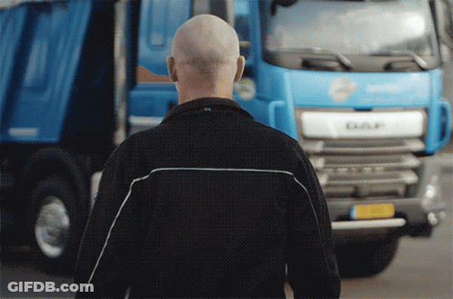 A Bald Man Stands In Front Of A Daf Truck GIF