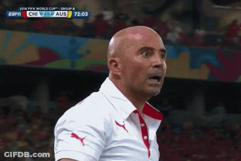 A Bald Man Stands In Front Of A Screen That Says Fifa World Cup Group B On It GIF