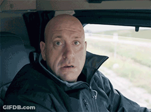A Bald Man Wearing A Black Jacket Looks Surprised GIF