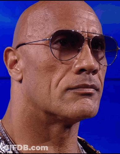 A Bald Man Wearing A Pair Of Sunglasses Looks At The Camera GIF