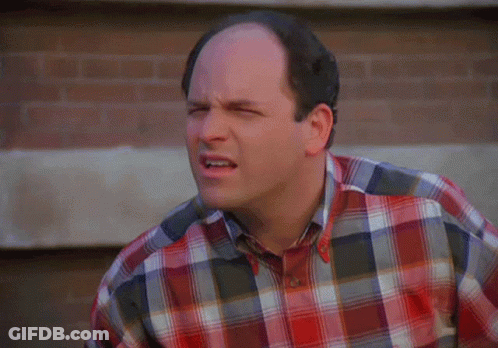 A Bald Man Wearing A Plaid Shirt Is Making A Face GIF
