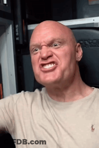A Bald Man Wearing A Polo Shirt Is Making An Angry Face GIF
