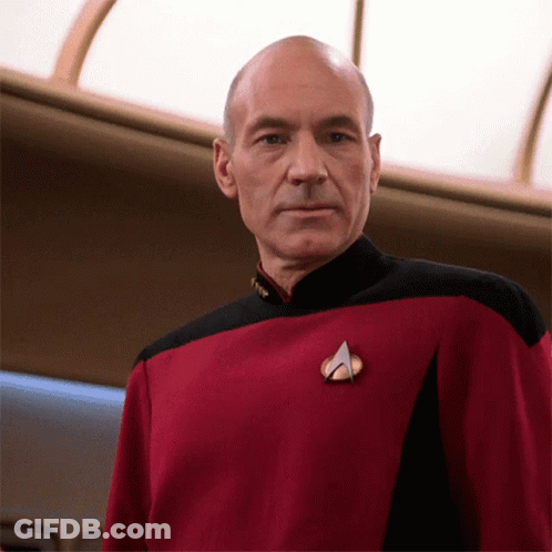 A Bald Man Wearing A Red And Black Uniform With A Badge That Says " Captain " GIF