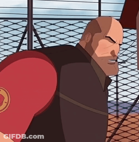 A Bald Man Wearing A Red Boxing Glove With A Circle On It Is Standing In Front Of A Chain Link Fence GIF