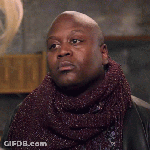 A Bald Man Wearing A Scarf And A Jacket GIF