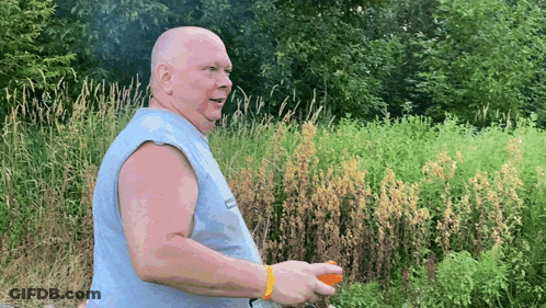 A Bald Man Wearing A Sleeveless Shirt That Says ' Ec ' On It GIF
