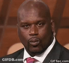 A Bald Man Wearing A Suit And Tie Is Blowing A Kiss . GIF