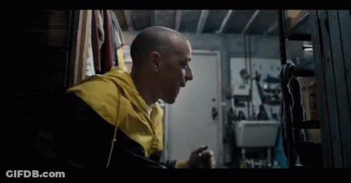 A Bald Man Wearing A Yellow And Black Jacket GIF
