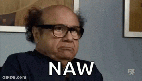 A Bald Man Wearing Glasses And A Black Shirt Is Sitting In Front Of A Wall And Saying Naw . GIF