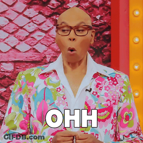 A Bald Man Wearing Glasses And A Colorful Floral Suit Says Ohh GIF