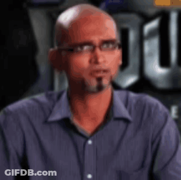 Bald Man With Glasses Looks At Camera GIF