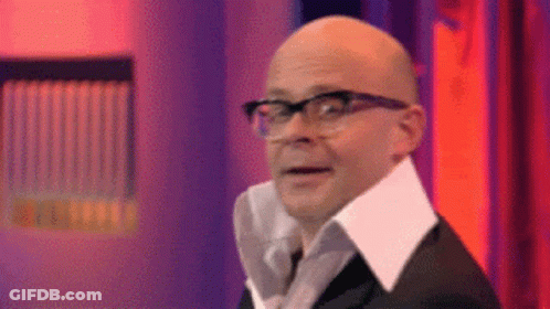 A Bald Man Wearing Glasses And A White Collar Is Making A Funny Face . GIF