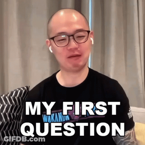 A Bald Man Wearing Glasses And Earbuds Says My First Question GIF