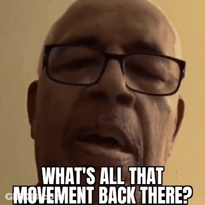 A Bald Man Wearing Glasses Is Asking What 'S All That Movement Back There . GIF