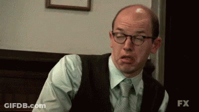 A Bald Man Wearing Glasses Is Making A Funny Face . GIF